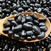 image of black beens in a spoon ontop a pile of black beans