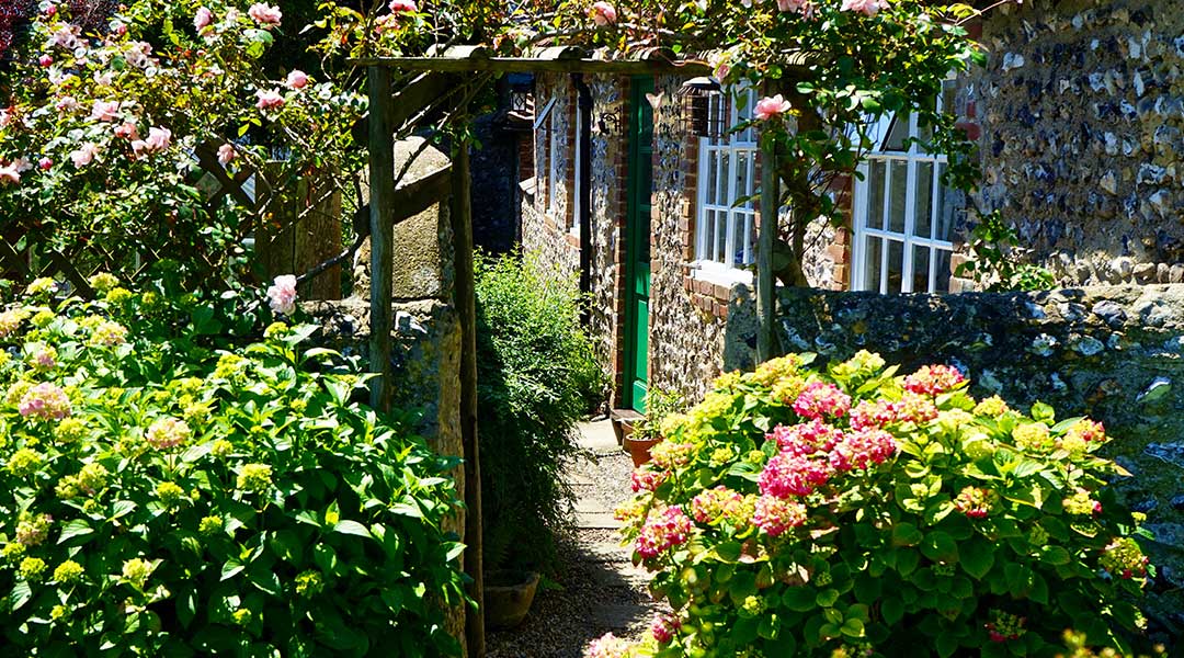 Image d’une maison en pierre avec un beau jardin fleuri